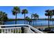 Balcony view showcasing tranquil waterfront, framed by lush trees and manicured landscaping at 611 Destiny Dr # 604, Ruskin, FL 33570