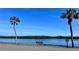 Scenic waterfront view with tranquil water, lush greenery, palm trees, and a charming bench for relaxation at 611 Destiny Dr # 604, Ruskin, FL 33570