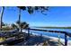 Charming waterfront wooden deck with picnic tables offers scenic views of the serene river and lush greenery at 611 Destiny Dr # 604, Ruskin, FL 33570