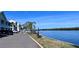 Scenic waterfront view with residents fishing by the canal and condo building in the background at 611 Destiny Dr # 604, Ruskin, FL 33570