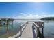 Picturesque wooden dock extending over serene waters with clear blue skies above at 701 Harbor Dr, Belleair Beach, FL 33786