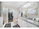 Well-lit bathroom featuring double sinks, granite counters, and a separate walk-in closet at 7673 Yale Harbor Dr, Wesley Chapel, FL 33545