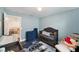 Light blue Bedroom offers a gray crib, a navy blue play mat, natural light, and a peek into the living room at 7673 Yale Harbor Dr, Wesley Chapel, FL 33545