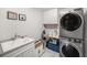 Practical laundry room with modern washer and dryer, sink, and cabinetry for ample storage at 7673 Yale Harbor Dr, Wesley Chapel, FL 33545