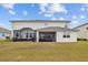 A view of the back of the home, showcasing the screened in porch and outdoor spaces at 7721 Roma Dune Dr, Wesley Chapel, FL 33545