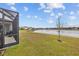 Expansive backyard featuring a serene lake view, lush lawn, and screened lanai, perfect for outdoor enjoyment at 7721 Roma Dune Dr, Wesley Chapel, FL 33545