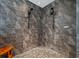 Modern bathroom showcasing a spacious tiled shower with two shower heads and a small wooden seat at 7721 Roma Dune Dr, Wesley Chapel, FL 33545