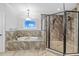 Bright bathroom featuring a soaking tub, glass enclosed shower and tile accent wall at 7721 Roma Dune Dr, Wesley Chapel, FL 33545