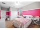 Bright bedroom with pink accent wall, carpet floors, and white furniture at 7721 Roma Dune Dr, Wesley Chapel, FL 33545