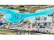 A full view of the luxurious community pool featuring white sandy beaches and a blue slide at 7721 Roma Dune Dr, Wesley Chapel, FL 33545
