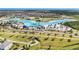 Aerial view of a community lagoon featuring turquoise waters, sandy beaches, palm trees, and water activities at 7721 Roma Dune Dr, Wesley Chapel, FL 33545