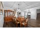 Formal dining room with wood floors, decorative china cabinet, coffered ceiling, and elegant chandelier at 7721 Roma Dune Dr, Wesley Chapel, FL 33545