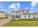 Beautiful two-story home with manicured lawn, brick driveway, and lush landscaping at 7721 Roma Dune Dr, Wesley Chapel, FL 33545
