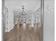 Elegant foyer with wood-look tile flooring and chandelier, leading to open living spaces at 7721 Roma Dune Dr, Wesley Chapel, FL 33545