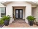 Inviting double-door entry with brick walkway and elegant potted plants at 7721 Roma Dune Dr, Wesley Chapel, FL 33545