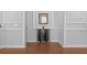 Hallway featuring hardwood floors, decorative wall trim, and a dark wood cabinet with decorative items at 7721 Roma Dune Dr, Wesley Chapel, FL 33545