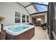 A hot tub is located just off the covered patio, near a grill and seating area at 7721 Roma Dune Dr, Wesley Chapel, FL 33545