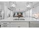 Open kitchen view of the kitchen island and adjoining living room with hardwood flooring and stylish decor at 7721 Roma Dune Dr, Wesley Chapel, FL 33545