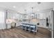 Bright kitchen with a center island, stainless steel appliances, modern lighting, and a built-in desk area at 7721 Roma Dune Dr, Wesley Chapel, FL 33545