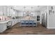 Beautiful kitchen featuring an island with seating, sleek appliances, modern backsplash, and hardwood flooring at 7721 Roma Dune Dr, Wesley Chapel, FL 33545