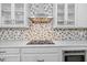 Close-up of kitchen featuring quartz countertops, a modern backsplash, and built-in appliances at 7721 Roma Dune Dr, Wesley Chapel, FL 33545