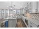 Modern kitchen featuring white cabinets, quartz countertops, an island with bar stools, and hardwood floors at 7721 Roma Dune Dr, Wesley Chapel, FL 33545