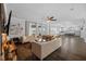 Open-concept living room featuring hardwood floors, comfortable seating, and seamless access to the kitchen at 7721 Roma Dune Dr, Wesley Chapel, FL 33545