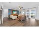 Bright living room with wood-look tile floors and access to a covered patio at 7721 Roma Dune Dr, Wesley Chapel, FL 33545