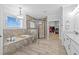 Luxury main bathroom featuring a soaking tub, glass shower, and dual sinks with granite countertops at 7721 Roma Dune Dr, Wesley Chapel, FL 33545