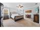 Spacious main bedroom featuring carpet floors, tray ceilings, decorative sconces and a large, upholstered bed at 7721 Roma Dune Dr, Wesley Chapel, FL 33545