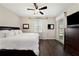Main bedroom suite features wood floors, a ceiling fan, and white bedding at 7721 Roma Dune Dr, Wesley Chapel, FL 33545