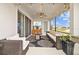 Covered patio with comfortable seating, fire pit, and outdoor bar area overlooking the lake at 7721 Roma Dune Dr, Wesley Chapel, FL 33545