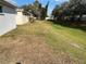 Wide backyard featuring lush grass, mature trees, and the side of the home with potential for outdoor activities at 8019 Brien Green Way, Temple Terrace, FL 33637