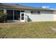 Backyard view featuring a sunroom, hose, and lawn at 8019 Brien Green Way, Temple Terrace, FL 33637