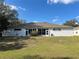 Backyard view featuring a sunroom, hose, and lawn at 8019 Brien Green Way, Temple Terrace, FL 33637