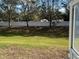 View of the backyard featuring a pristine white fence, grassy area and trees that provide shade and privacy at 8019 Brien Green Way, Temple Terrace, FL 33637