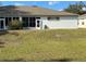 Backyard view featuring a sunroom, hose, and lawn at 8019 Brien Green Way, Temple Terrace, FL 33637