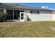 Backyard view featuring a sunroom, hose, and lawn at 8019 Brien Green Way, Temple Terrace, FL 33637