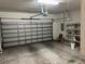 Spacious garage with ample storage featuring a large door, shelving units and overhead lighting at 8019 Brien Green Way, Temple Terrace, FL 33637