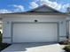 Garage exterior featuring a white door, modern lighting fixtures, and visible house number for easy identification at 8019 Brien Green Way, Temple Terrace, FL 33637