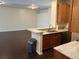 Bright kitchen featuring granite countertops, wooden cabinets, stainless steel dishwasher, and dark wood-look flooring at 8019 Brien Green Way, Temple Terrace, FL 33637
