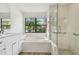 Bright bathroom with a large soaking tub, walk-in shower and white cabinets at 887 Lucas Ln, Oldsmar, FL 34677