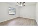 Bright bedroom with wood-look flooring, ceiling fan, and window view at 887 Lucas Ln, Oldsmar, FL 34677