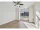 Bedroom showcasing hardwood floors, a ceiling fan, and a large window providing natural light at 887 Lucas Ln, Oldsmar, FL 34677