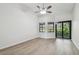 Bedroom showing wood-look floors, ceiling fan, and black trimmed windows at 887 Lucas Ln, Oldsmar, FL 34677