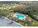 Aerial view of a community pool and clubhouse with ample parking and palm trees at 887 Lucas Ln, Oldsmar, FL 34677