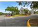 Community entrance sign surrounded by mature landscaping and colorful flowers at 887 Lucas Ln, Oldsmar, FL 34677