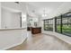 Bright dining room featuring large windows, updated flooring, and modern light fixture at 887 Lucas Ln, Oldsmar, FL 34677