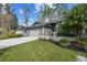 Well-maintained single-story home with a two-car garage, palm tree, and landscaped yard at 887 Lucas Ln, Oldsmar, FL 34677