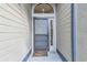 Welcoming front door with a storm door, sidelight window, and decorative welcome mat at 887 Lucas Ln, Oldsmar, FL 34677
